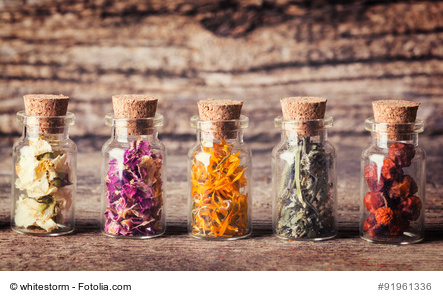 Nature medicine . Herbs in bottles on wooden background.